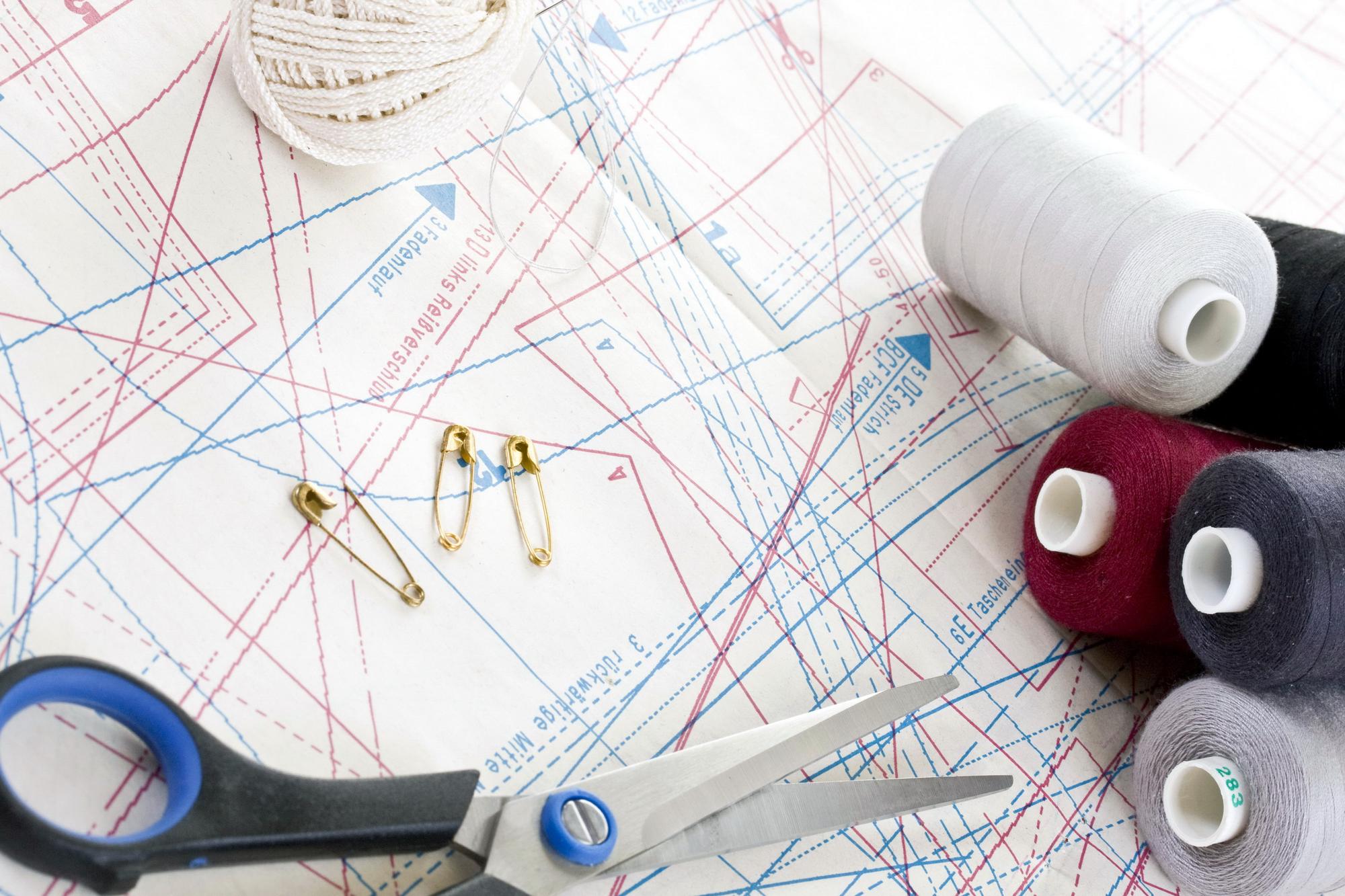 Workspace with threads, needle and pattern sketch